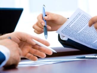 Two people reviewing a document with pens, illustrating an RFP for outside counsel