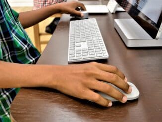 Microsoft buyouts: hands on a keyboard and mouse at an office desk