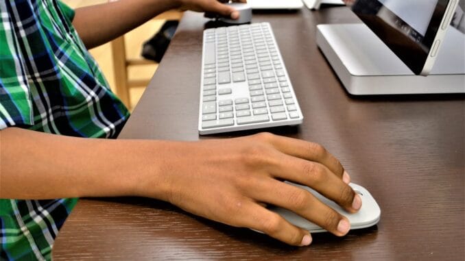 Microsoft buyouts: hands on a keyboard and mouse at an office desk