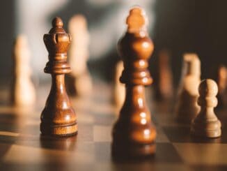 Wooden chess king pieces on a board, new general counsel strategy