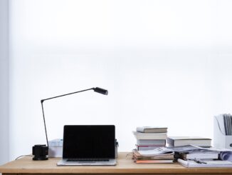 Laptop and paperwork on a desk as outside counsel work moves in-house