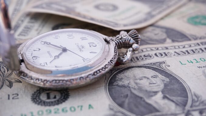 Pocket watch on US dollar bills, a nod to partner billing rates rising as billable hours fall